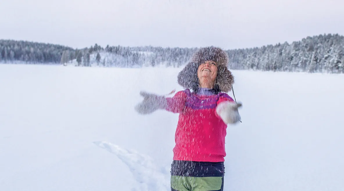 Indira Niittyvuopio heittää lunta ilmaan karvahattu päässään.