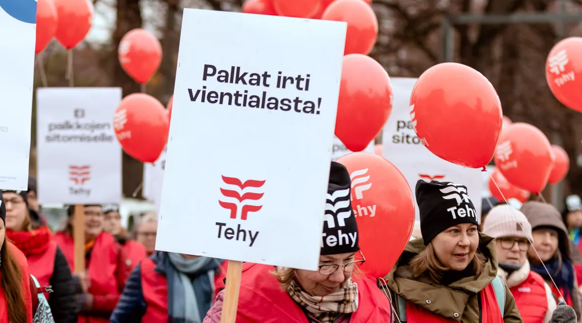 Tehyläiset mielenosoituksessa. Kyltissä lukee Palkat irti vientialasta