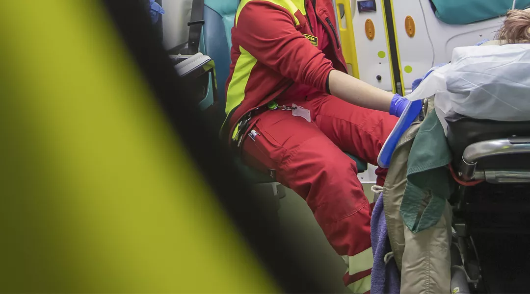 Anonyymi ensihoitaja hoitaa potilasta ambulanssissa.