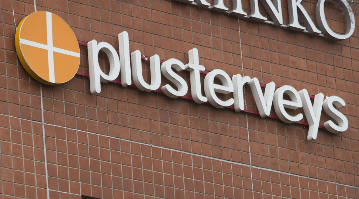 PlusTerveyden logo talon seinässä