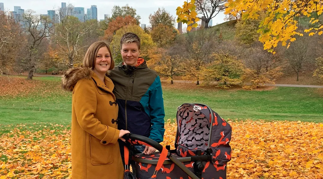 Saana Adam-Kitinoja ja vaimo Rebecca lastenrattaiden kanssa puistossa.