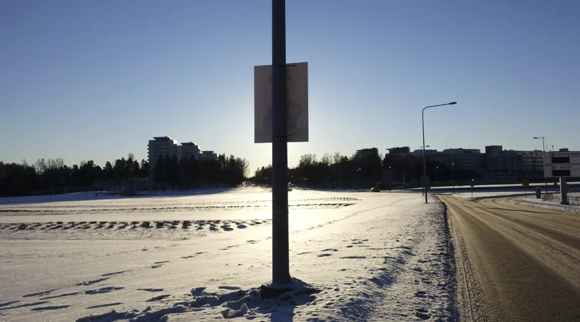 Aluevaalimainos tien poskessa aurinkoisessa säässä.