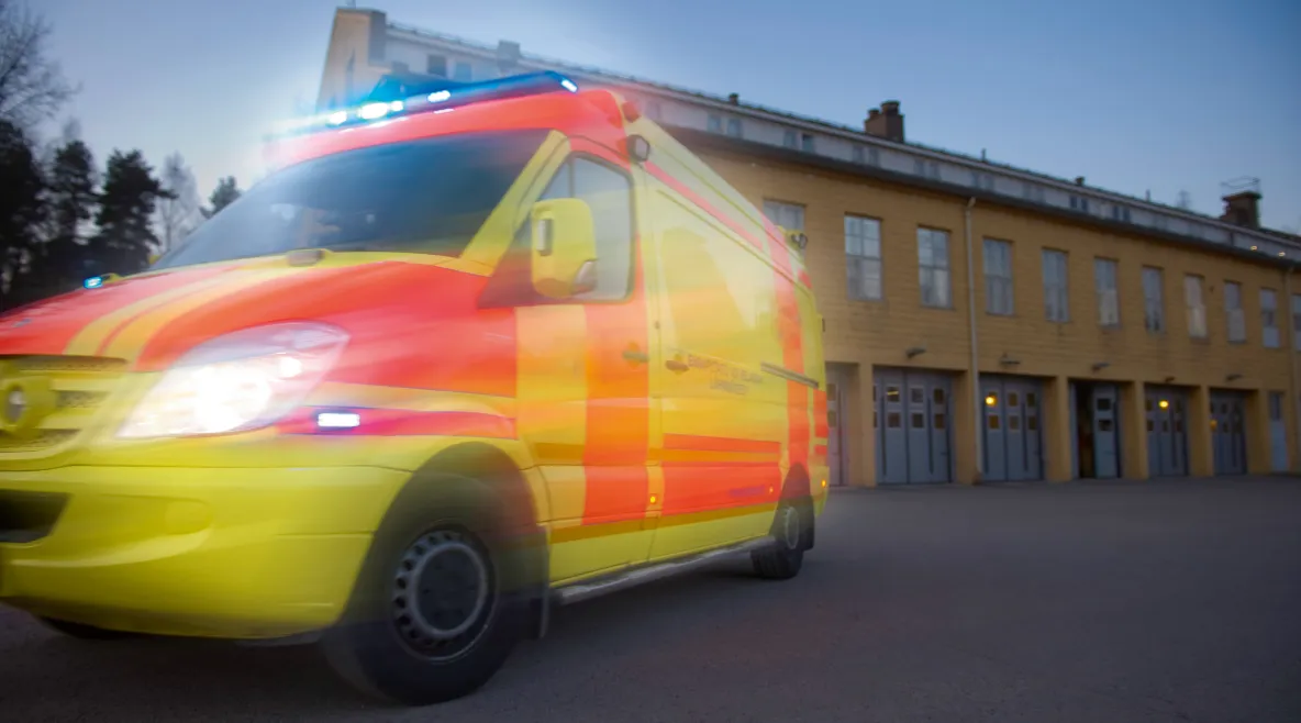 Ambulanssi ajaa kameran ohi, kuva epäselvä. 