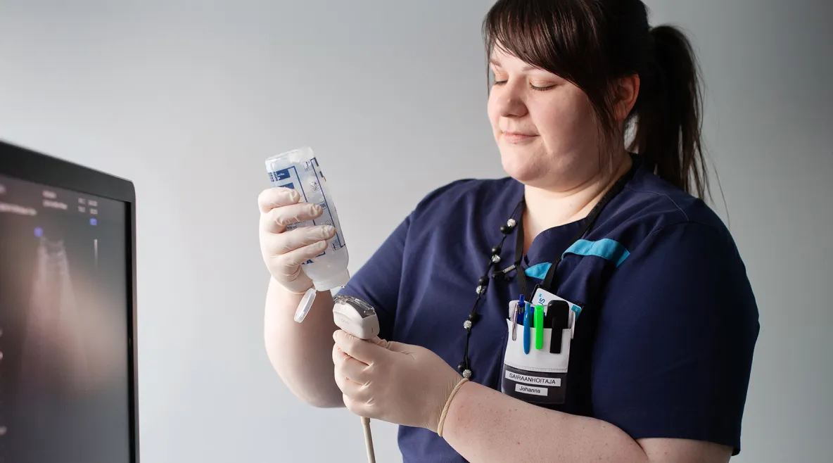 Maksahoitaja Johanna Salmivuori työasussaan työpaikallaan.