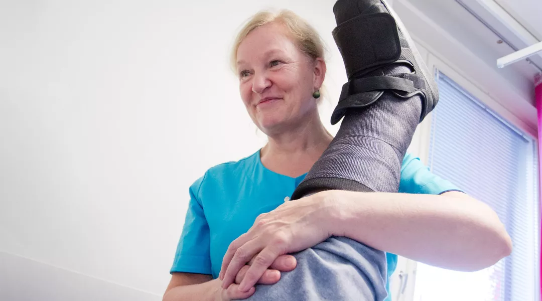Fysioterapeutti Sinikka Rovio kannattalee kipsattua jalkaa.