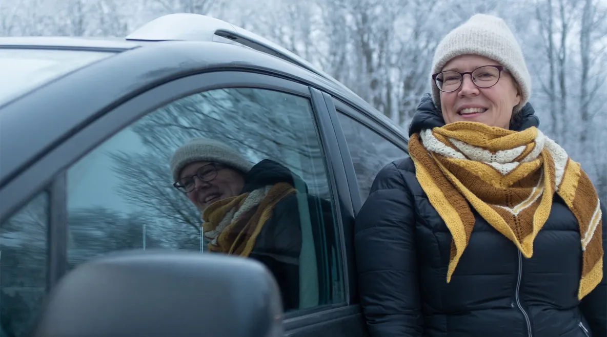 Päivi Laine auton vieressä.