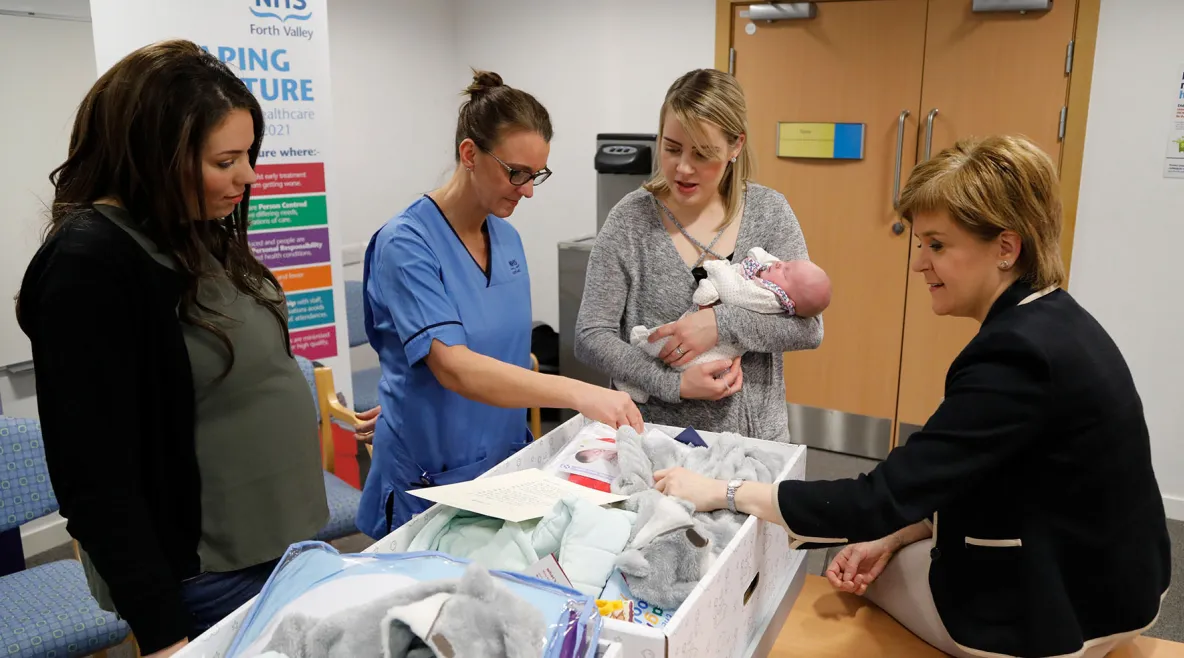 Pääministeri Nicola Sturgeon tutustuu äitiyspakkauksen sisältöön. 