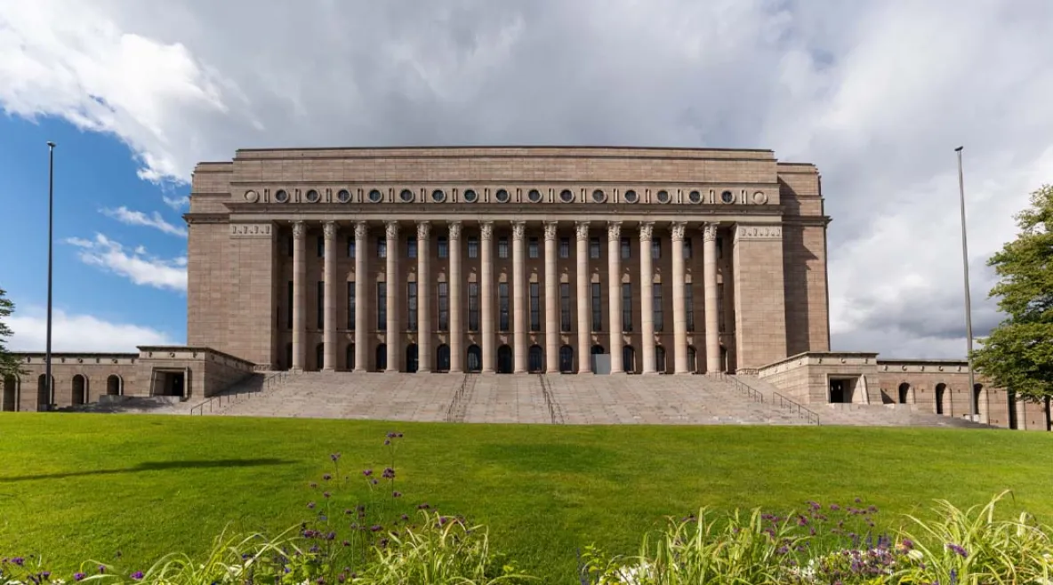 Eduskuntatalo kuvatutna ulkoapäin keväisessä maisemassa.