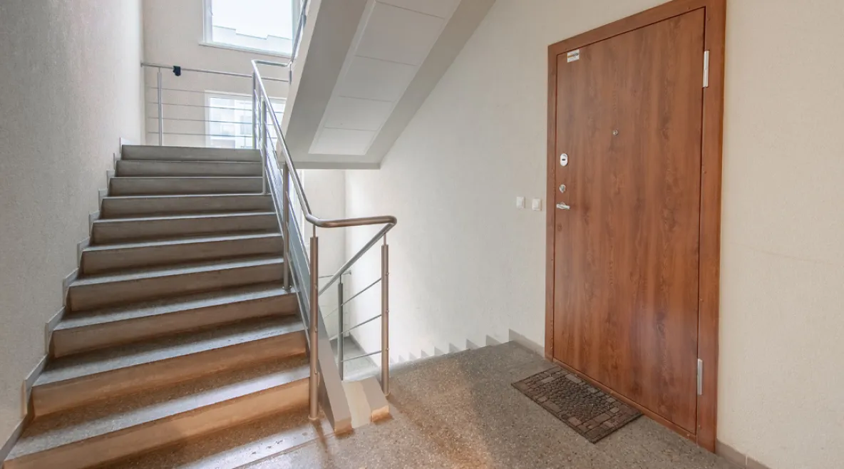 Rappukäytävä, jossa näkyy asunnon ovi ja portaat. Ensihoitajat joutuivat perääntymään rappukäytävään turvaan, kun potilas uhkasi heitä veitsellä Tampereella. 