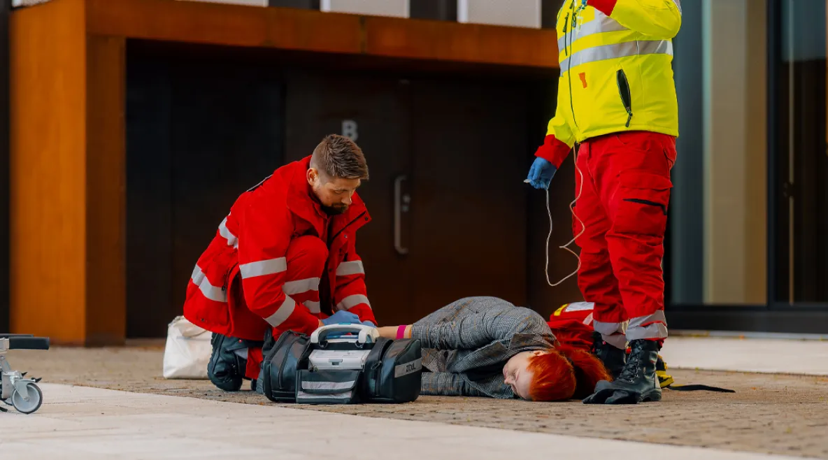 Tehyn juristi: Ensihoitajien kohtaama väkivalta viimein rikoslakiin, mutta saman tulisi koskea koko sote-henkilöstöä. Ensihoitajat auttavat maassa makaavaa potilasta julkisella paikalla.