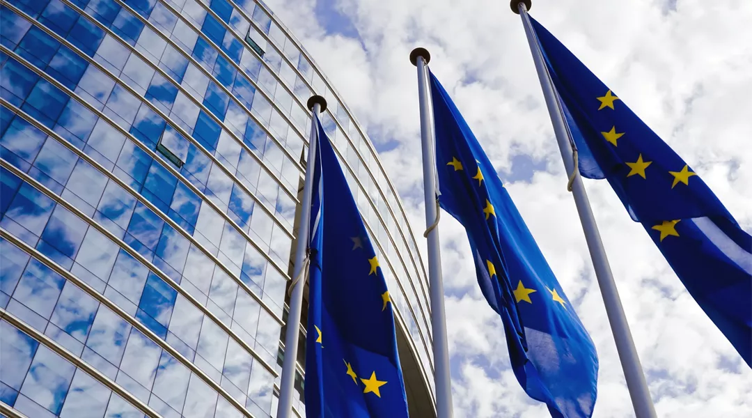 EU-liput lipputangossa korkean rakennuksen edustalla.