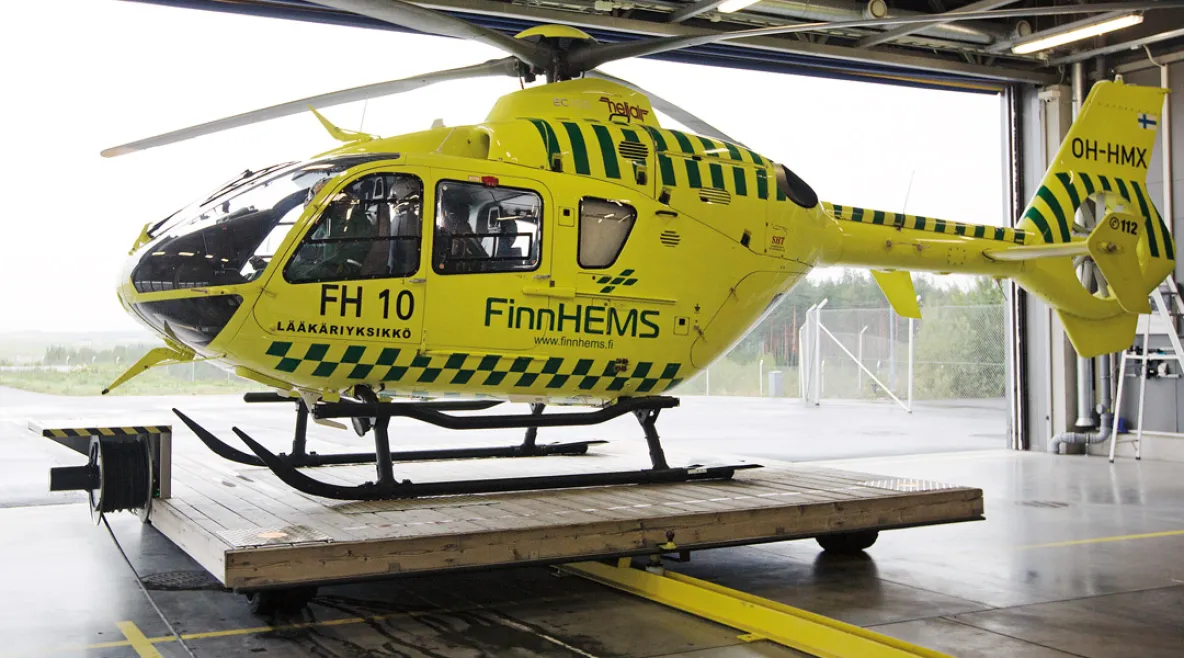 FinnHEMS helikopteri siiretään ulos hallista liikkuvalla lavetilla. 