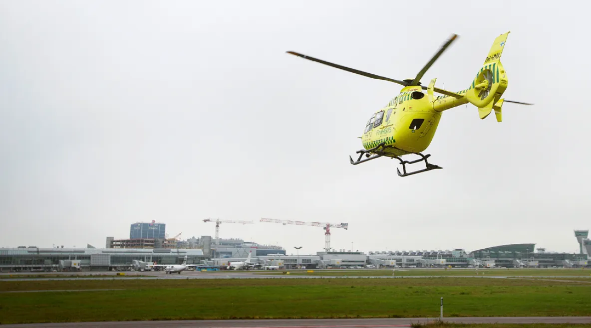 FinnHEMSin lääkärihelikoptereissa työskentelevien ensihoitajien vuosiloma pitenee parhaimmillaan jopa 13 päivää. FinnHEMS helikopteri lentämässä kohti sairaalarakennuksia sumuisessa säässä.