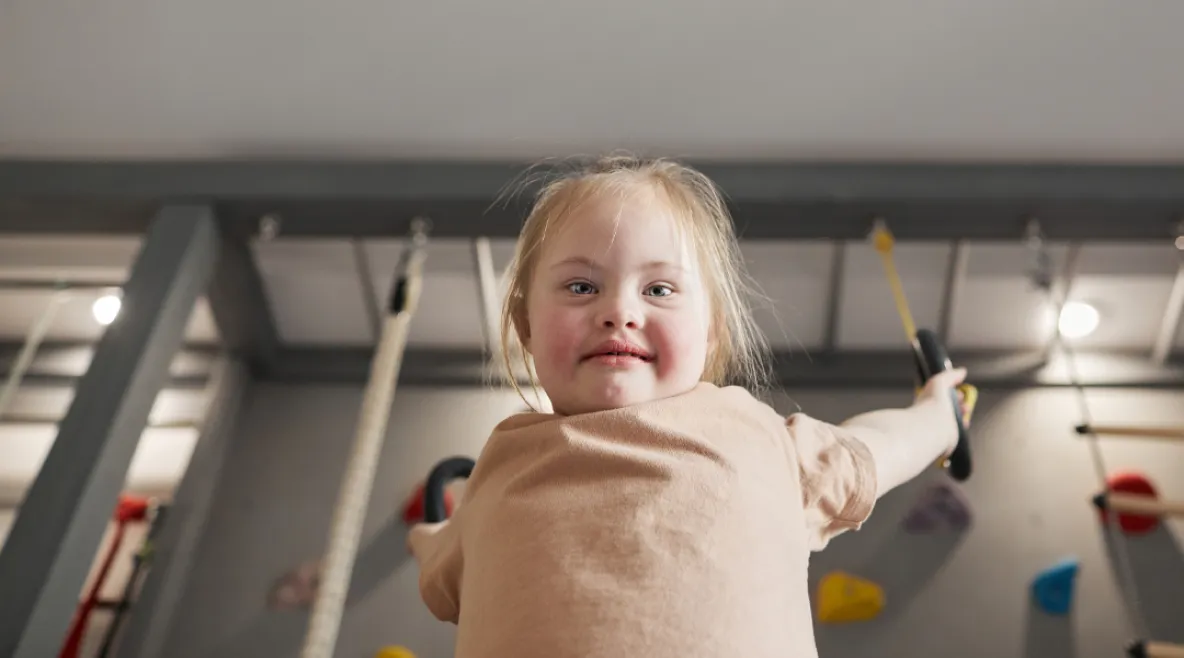 Kehitysvammaliiton ja Autismiliiton toiminta on vaarassa loppua kokonaan hallituksen sotejärjestöjen leikkauksien vuoksi. Nuori kehitysvammainen tyttö leikkii voimistelurenkaissa.