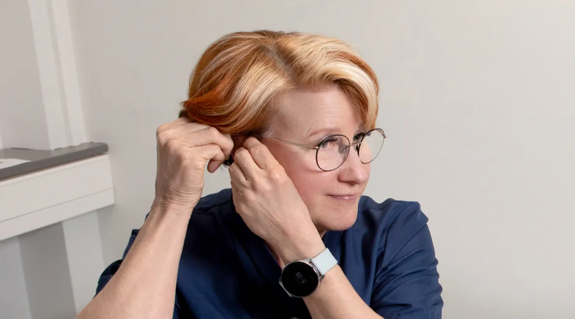 Sairaanhoitaja Leila Hällfors laittaa korvaansa kuulolaitetta.