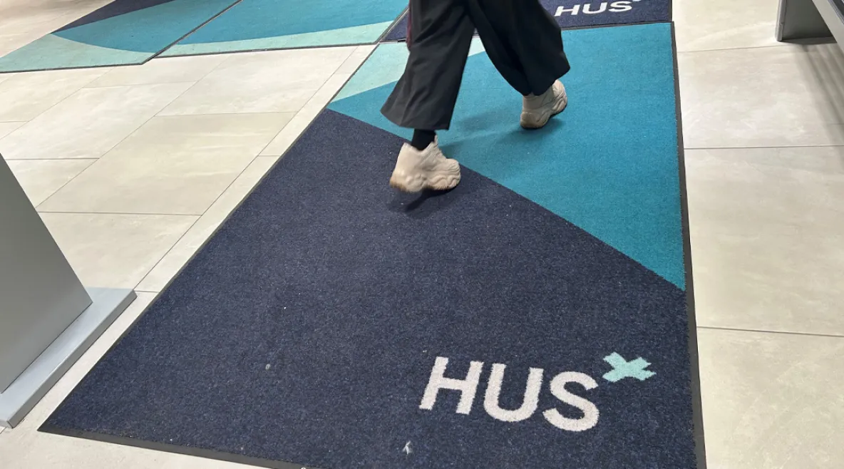 Alle 13-vuotiaiden lasten psykiatriseen hoitoon pääsee Husissa nopeasti. Nuori kävelee sairaalassa maton yli, jossa Husin logo.