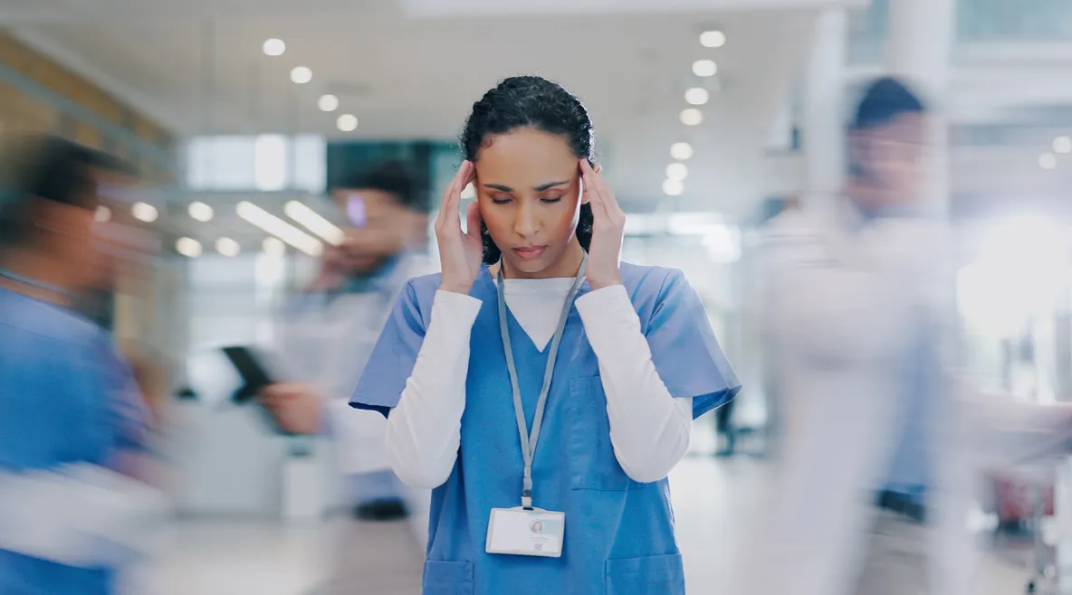 Sairaanhoitaja hälinää täynnä olevassa työympäristössä. 