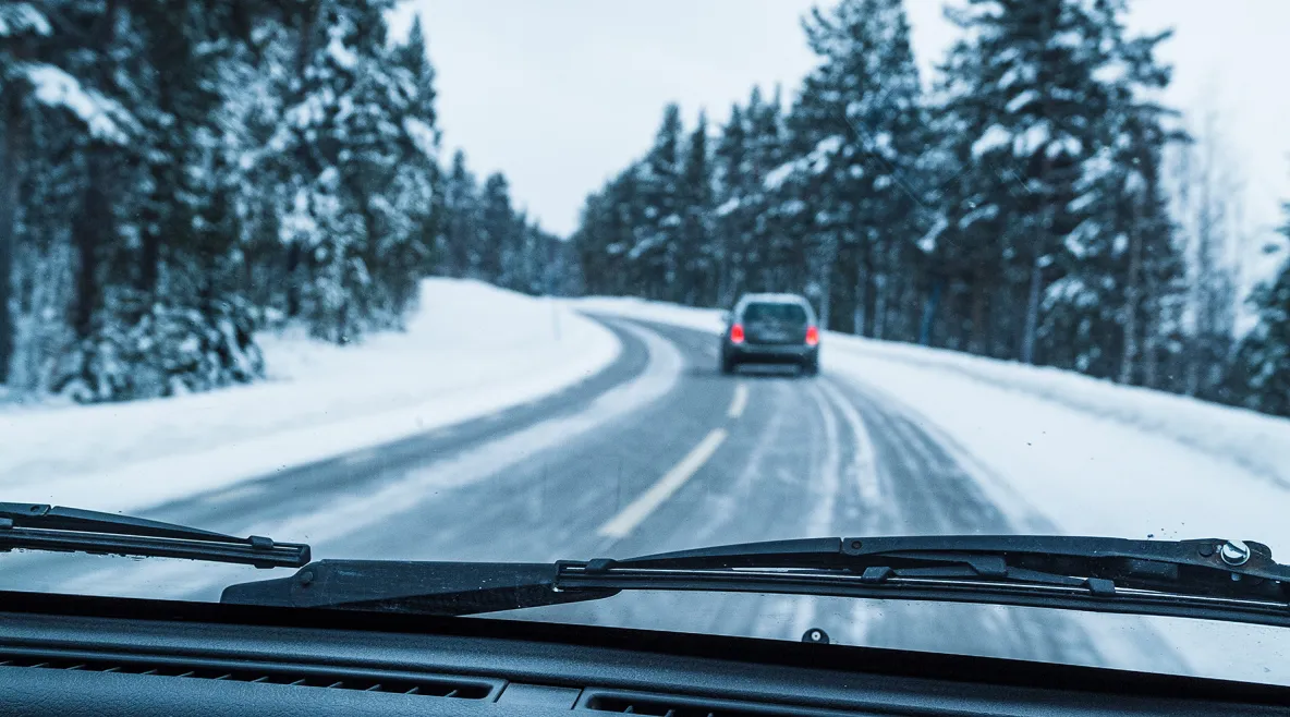 Talvinen maantie, jossa näkyy edellä ajava auto