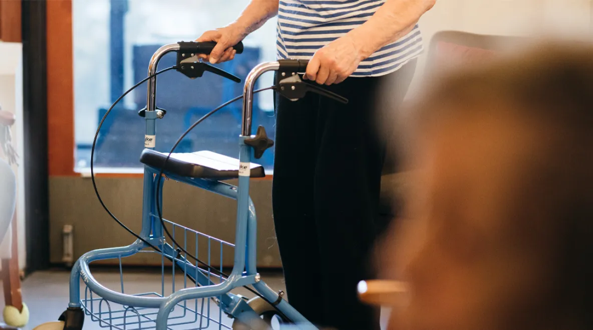 Vanhus kävelytuen kanssa.