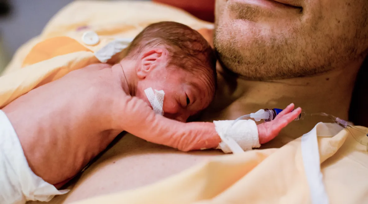 Pieni keskosvauva lepää isänsä rinnalla.