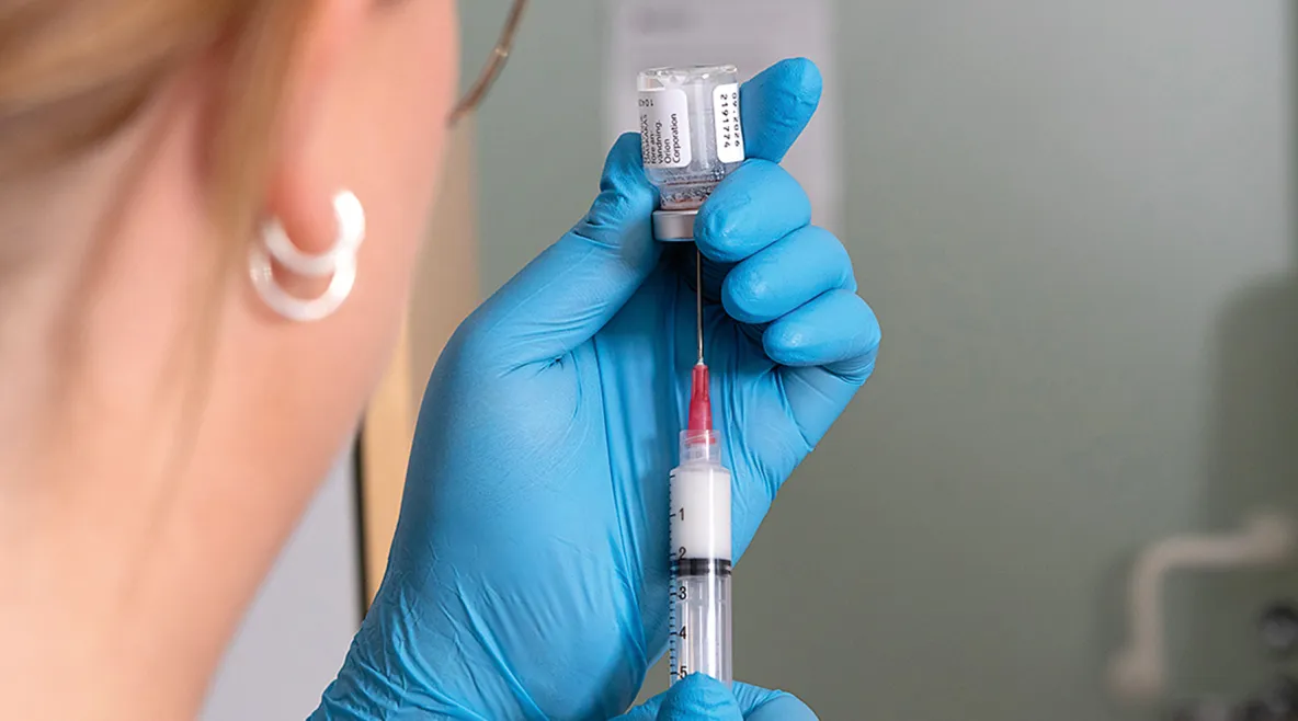 Sairaanhoitaja laittaa lääkettä ruiskuun.