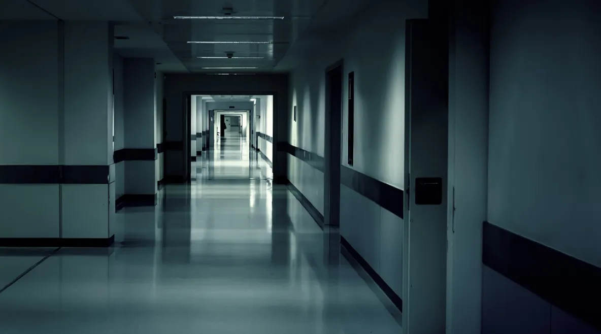 Generitiivinen kuva tyhjästä ja synkästä sairaalan käytävästä.