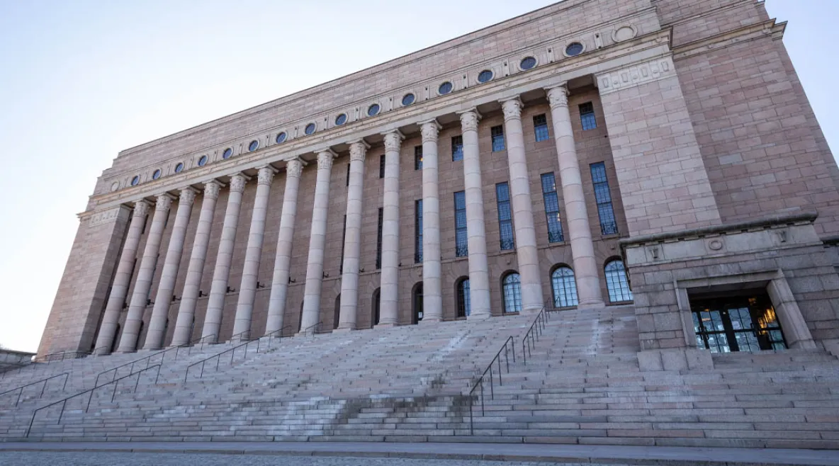 Eduskuntatalon rappuset kuvattuna talvella. Portailla hienoisesti lunta.