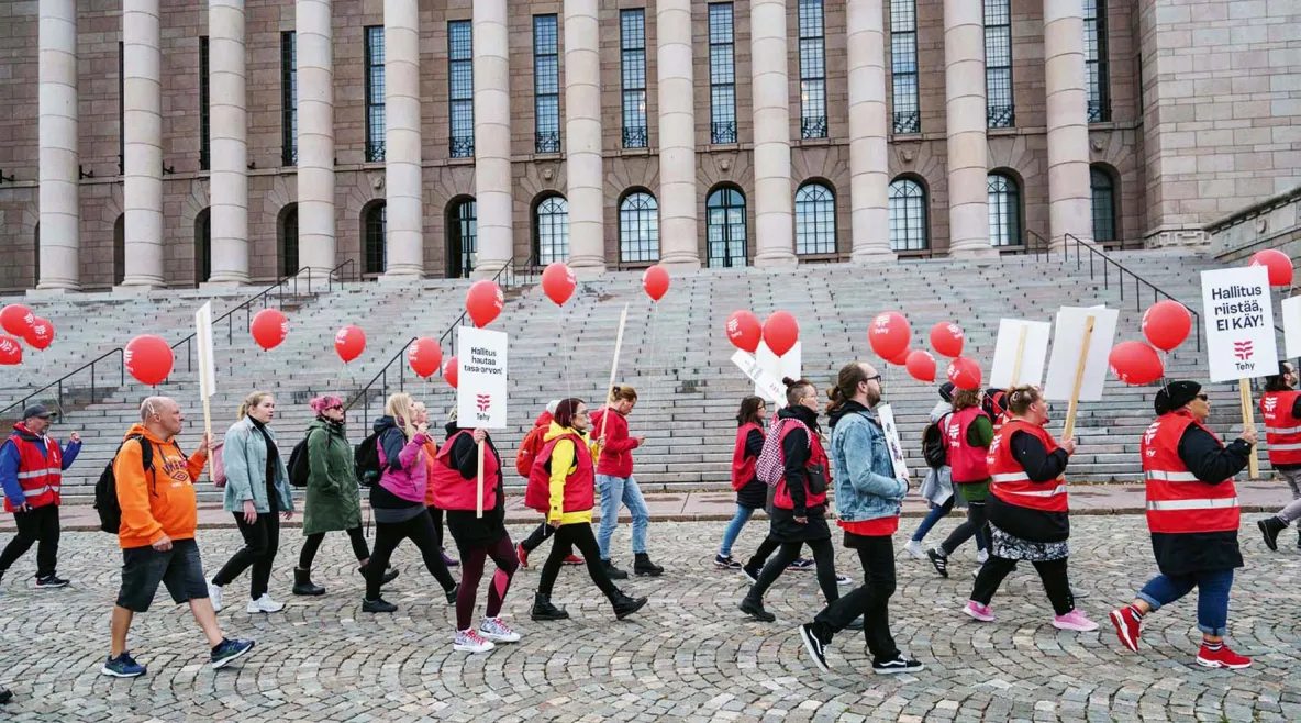 Tehyläiset marssivat eduskuntatalon ohi.