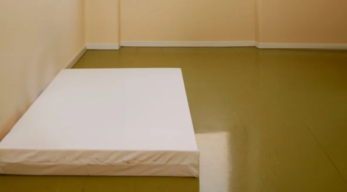 Sairaalan suljetun osaston huone, jossa lattialla pelkkä patja.