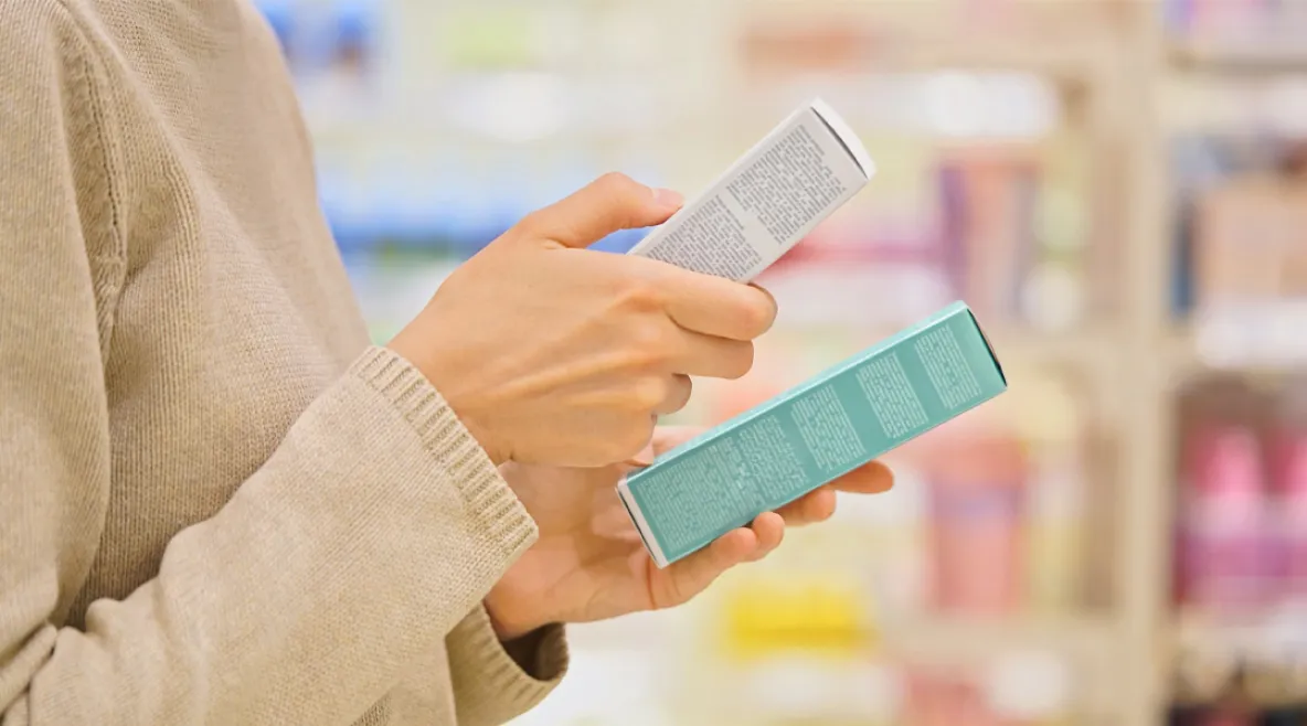 Naisvaltaisten alojen palkansaajien ostovoima on kohentunut ammattiliittojen neuvottelemien palkankorotusten ansiosta – kuvassa henkilö vertailee tuotteita kaupassa.