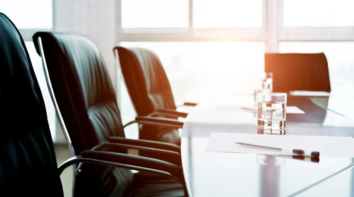 Neuvottelupöydän ääressä mustia nahkatuoleja.