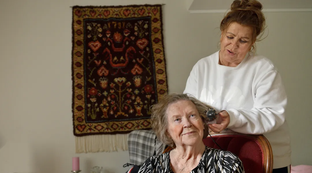 Katariina Salminen laittaa äitinsä hiuksia.