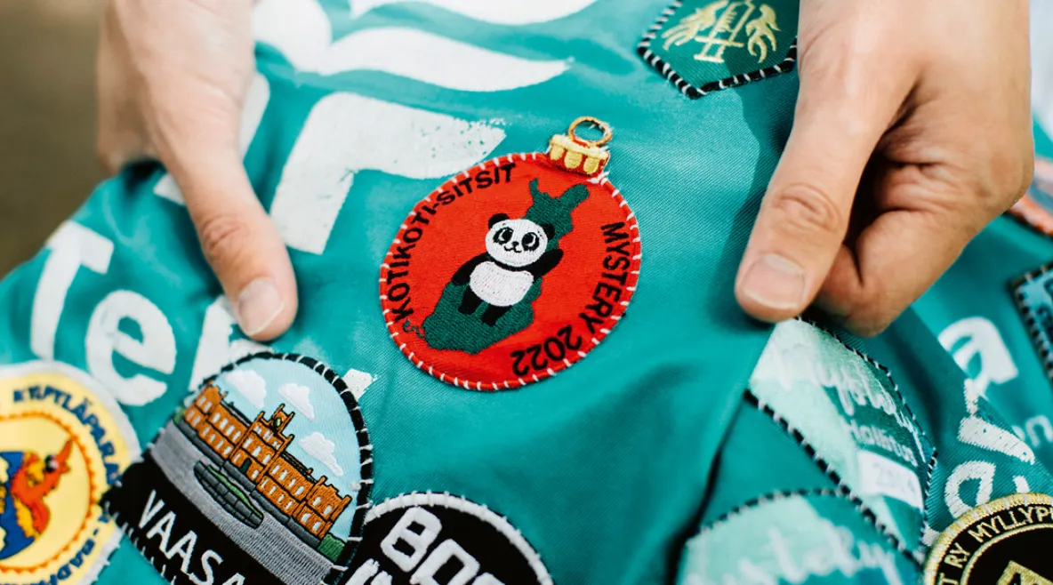 Opiskelija esittelee opiskeluhaalareitaan ja niissä olevia haalarimerkkejä.