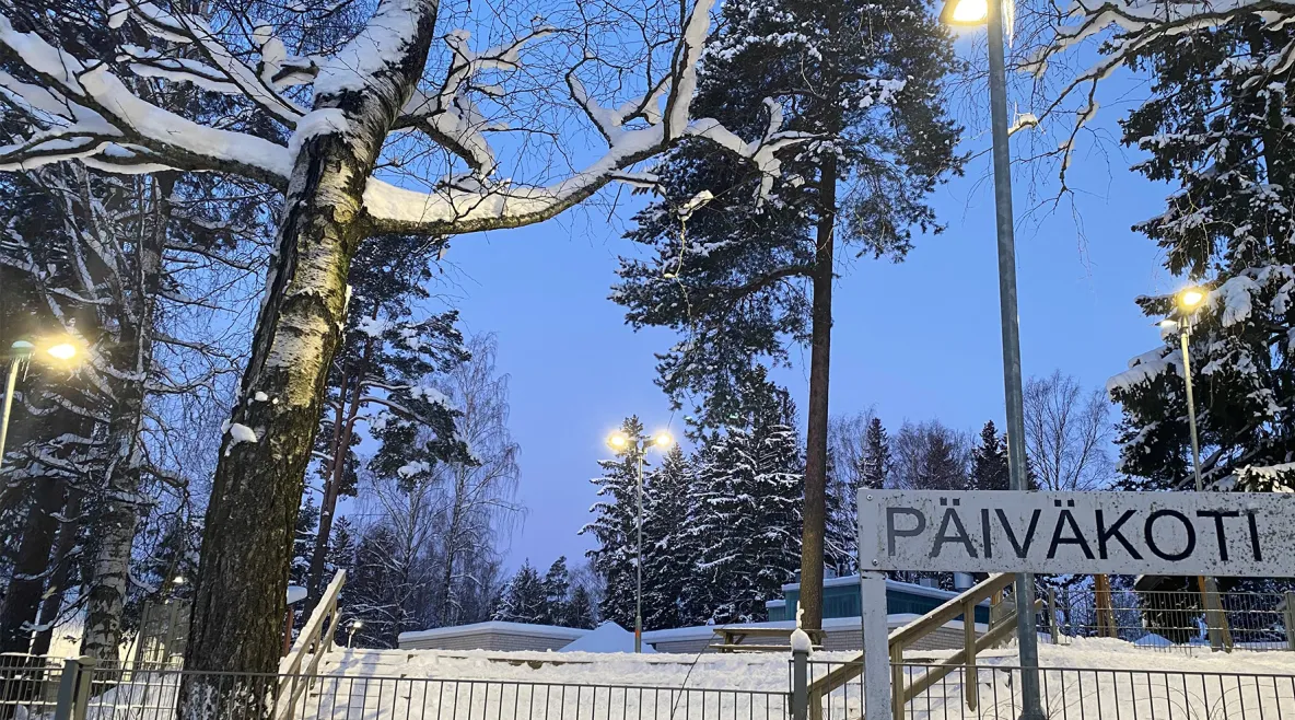 Päiväkotikyltti lumisessa ympäristössä. 
