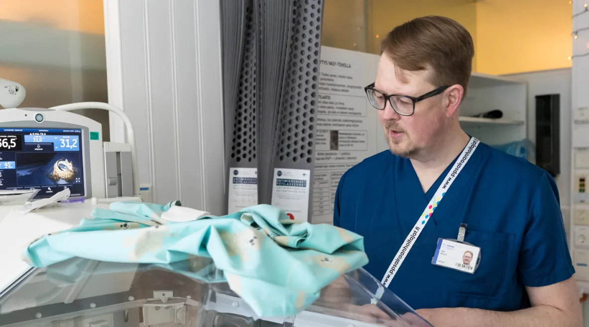 Kätlä Erik Indola Oysin vastasyntyneiden teho-osastolla keskoskaapin äärellä.