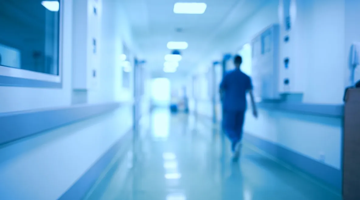 Psykiatrinen potilas pahoinpiteli sairaanhoitajan. Käräjäoikeus piti sairaala Novassa tapahtunutta väkivaltaa voimakkaana ja tuomitsi potilaan maksamaan sairaanhoitajalle 3 500 euroa korvauksia. Kuvituskuva, jossa hoitaja kävelee sairaalan käytävää poispäin kamerasta.