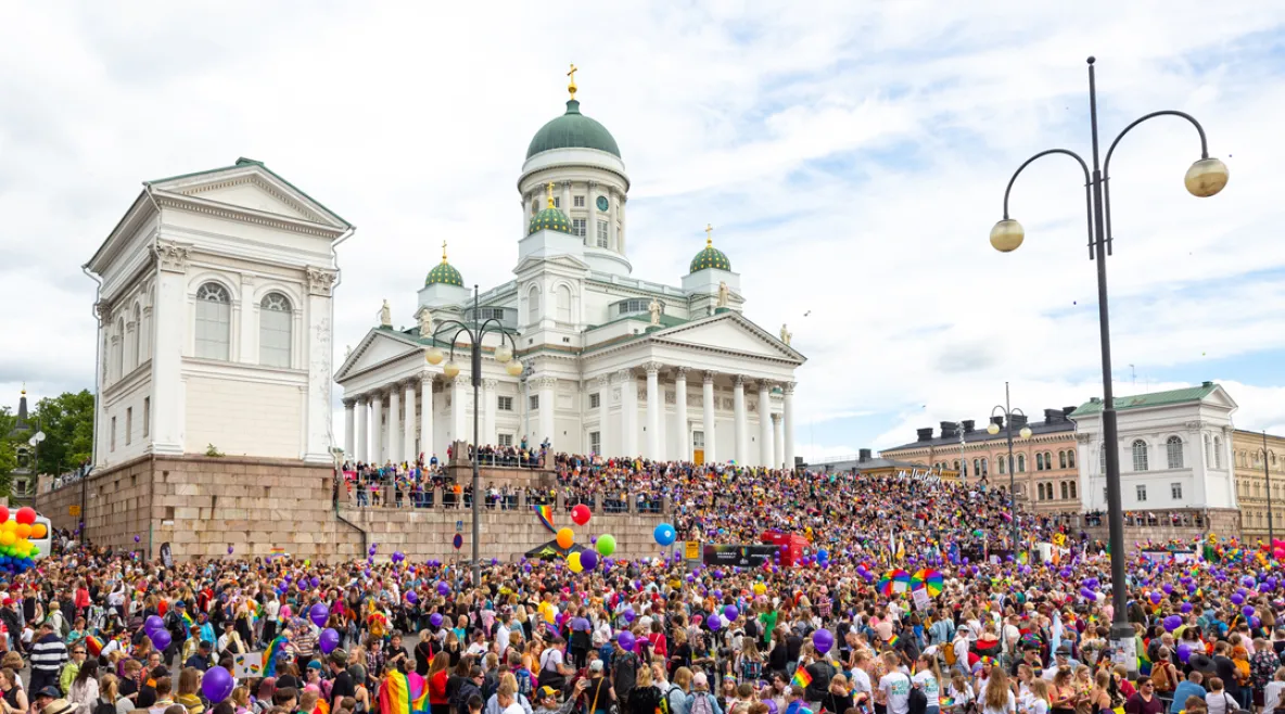 Ihmisiä osallistumassa Pride-kulkueeseen Helsingin Senaatintorilla.