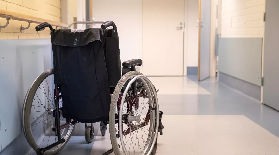 Pyörätuoli tyhjällä sairaalakäytävällä.
