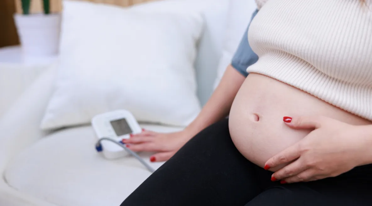 Raskaana oleva nainen mittaa verenpainettaan.