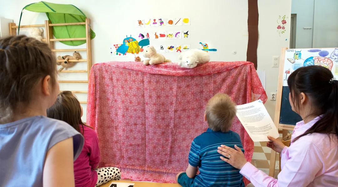 Lapset katsovat nukketeatteria päiväkodissa.