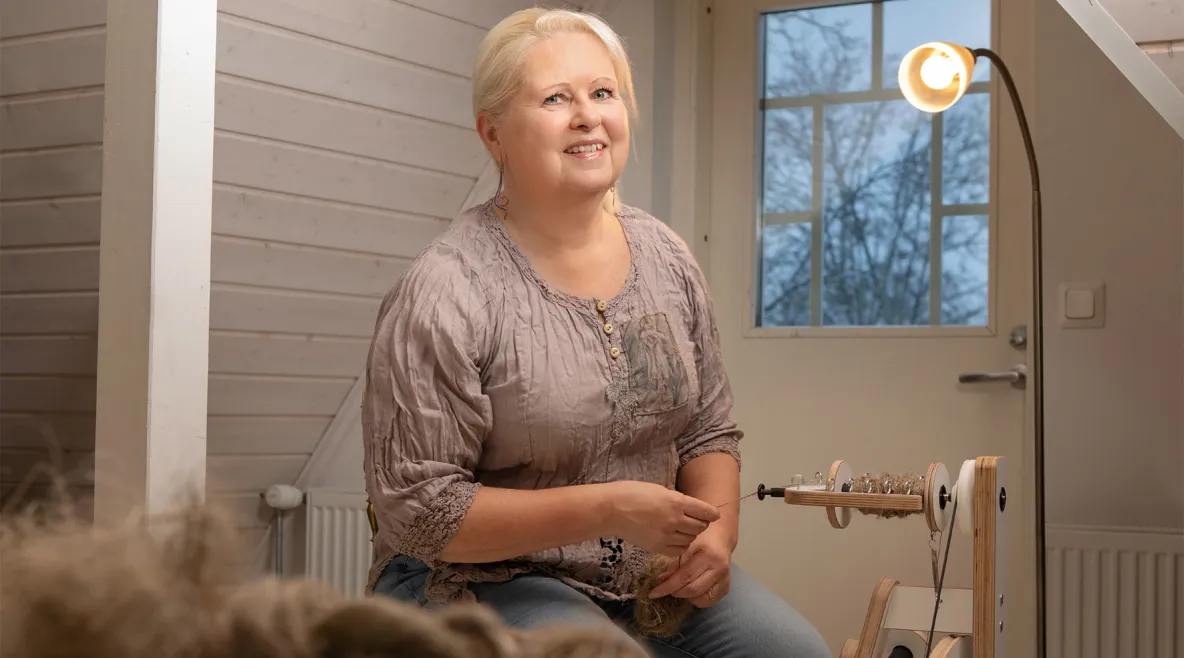 Tiina Sosoi kehrää lankaa modernilla rukilla.