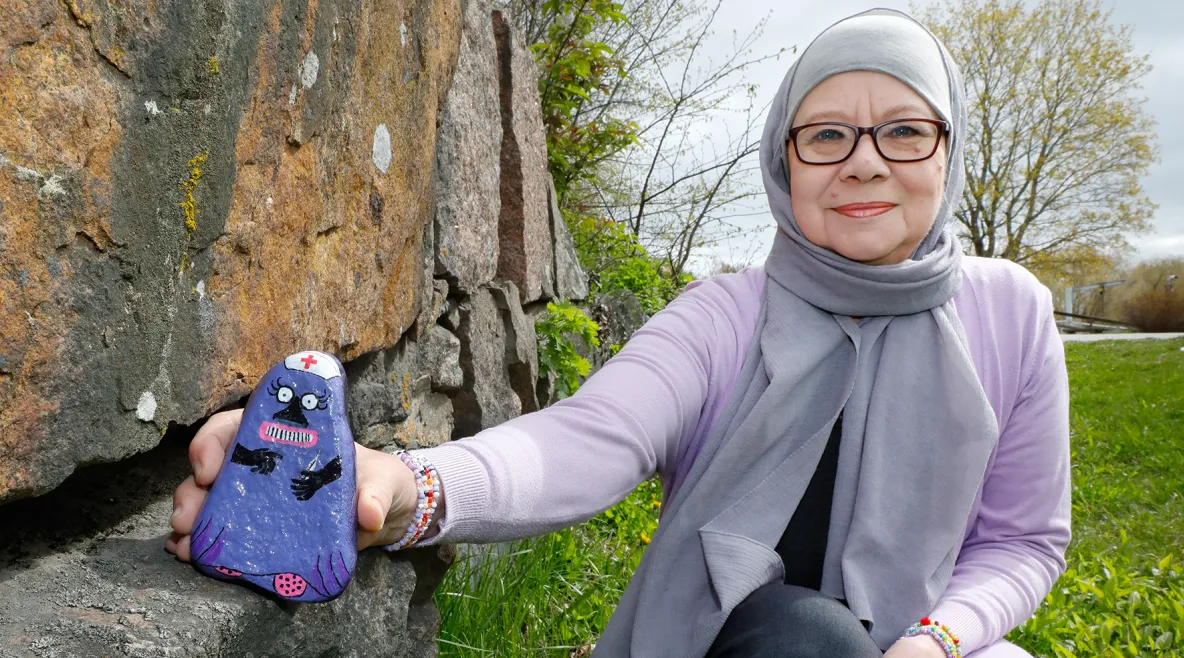 Tiina De Stele ja kivi, joka on maalattu hoitajalta näyttäväksi Muumien mörköhahmoksi.