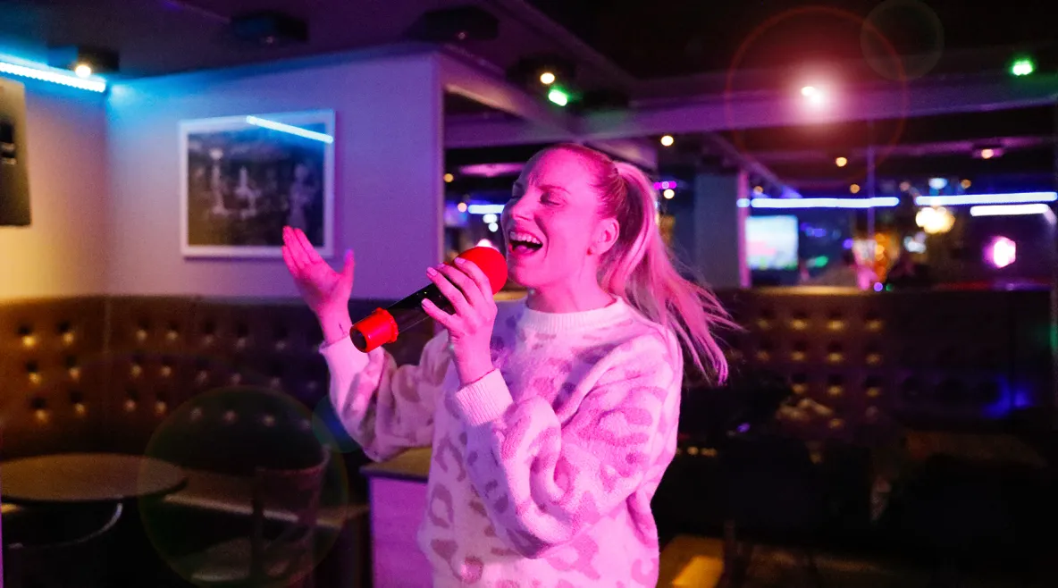 Emmi Bogdanoff laulaa karaokebaarissa.