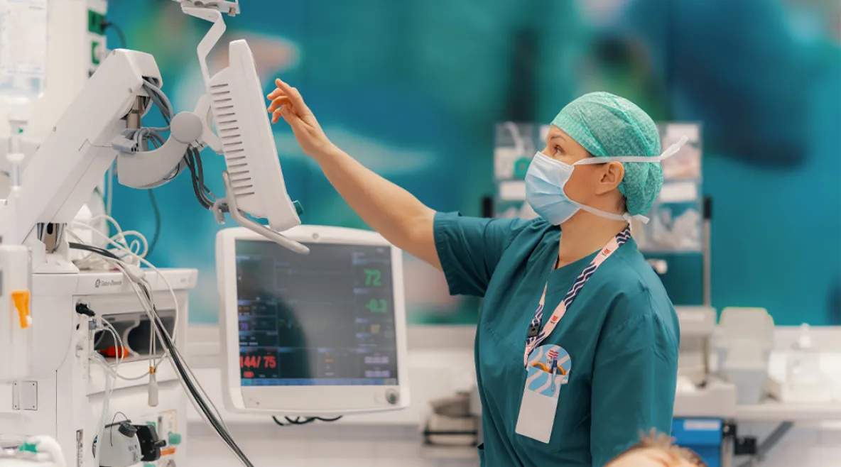 Hoitaja käy läpi leikkaussalin laitteita.