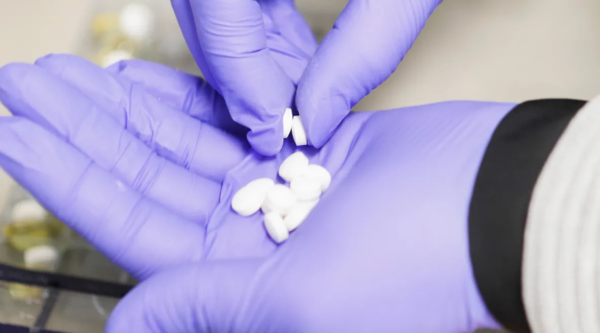 Tabletteja suojakäsineellisellä kämmenellä. 