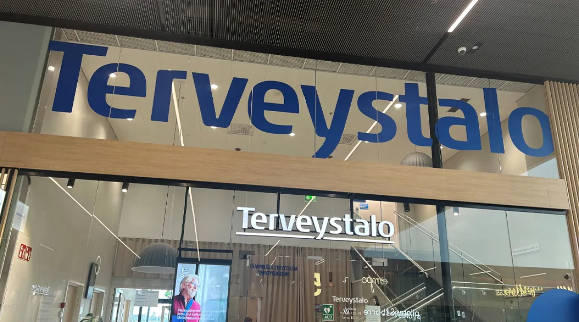 Terveystalon logo rakennuksen seinällä.