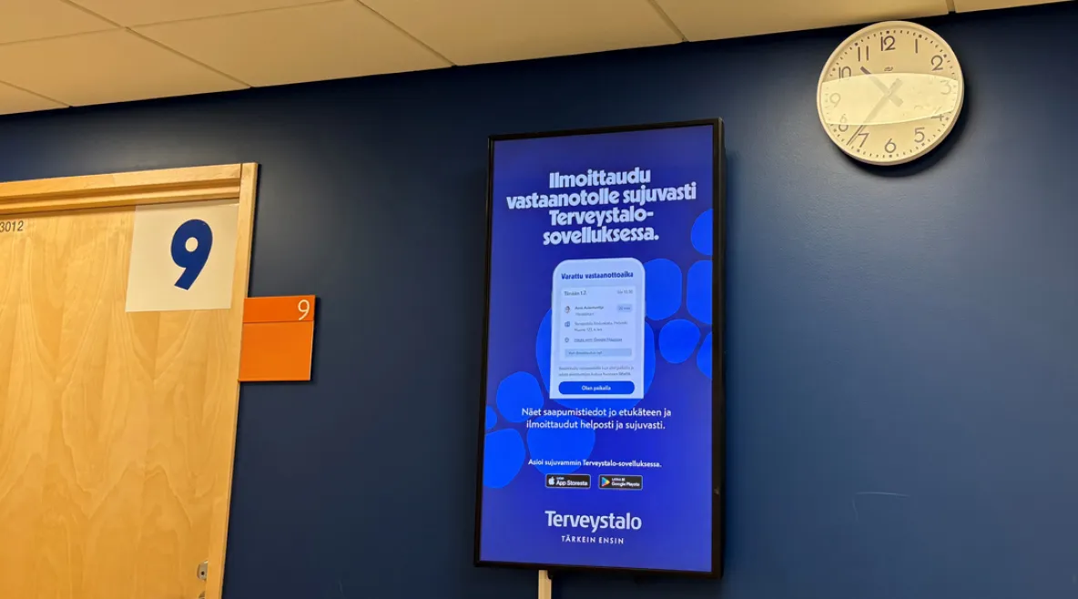 Terveystalo aloittaa uudet, entistä isommat muutosneuvottelut. Terveystalon seinällä sähköinen mainostaulo Terveystalon omasta sovelluksesta.