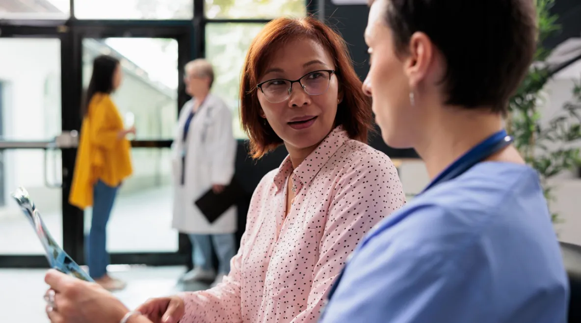 Hoitaja keskustelemassa potilaan kanssa.