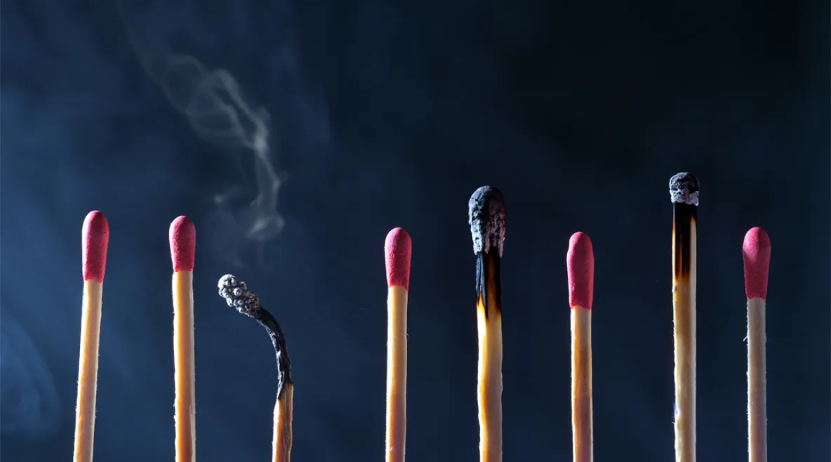 Tulitikkuja rivissä kuvaamassa työssä jaksamista ja uupumista. Välissä on palaneita tikkuja.