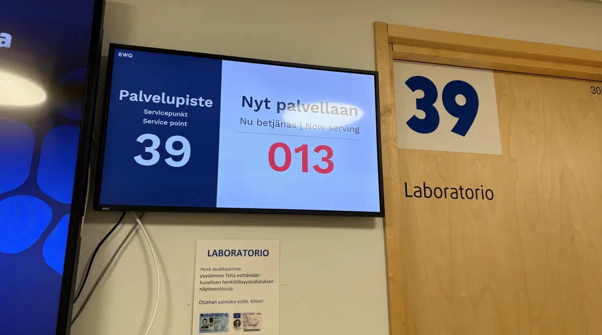 Työterveyshuolto maksoi noin 600 euroa työntekijää kohti. Yksityisen lääkäriaseman odotustila ja vuoronumerot television näytöllä.